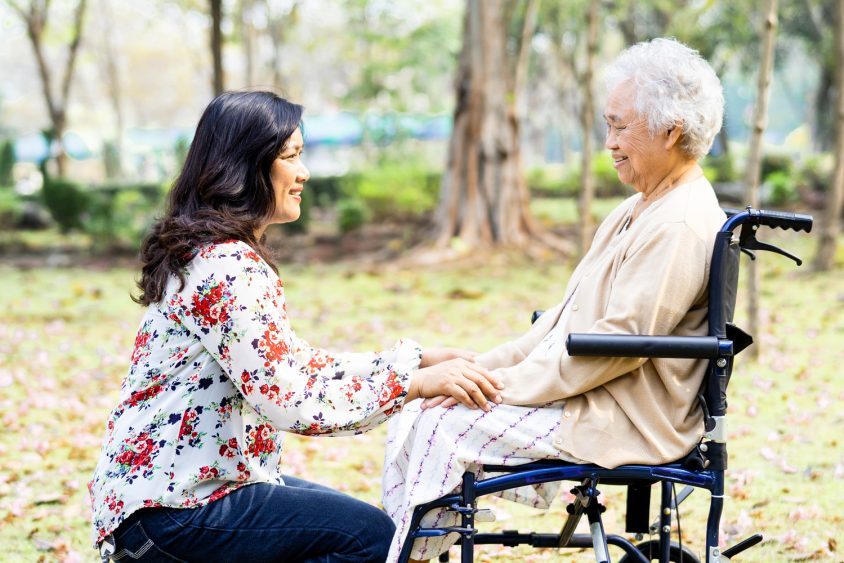 Asian senior or elderly old lady woman patient with care, help and support on wheelchair in park in holiday, healthy strong medical concept.